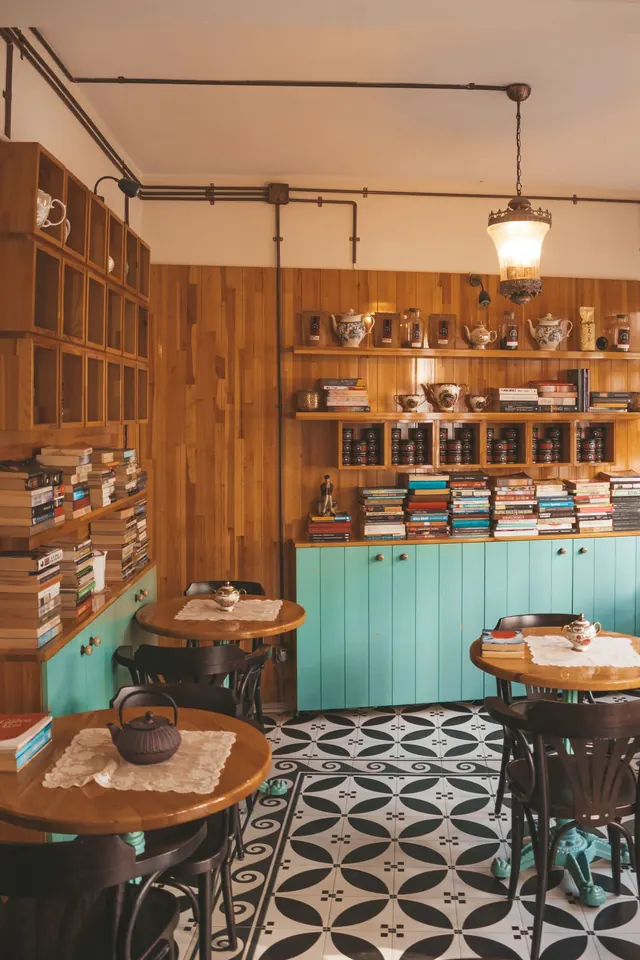 A café interior with wooden shelves and a patterned floor.
