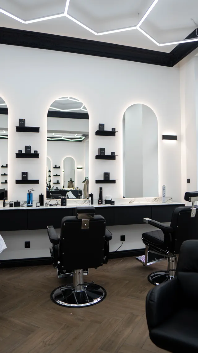 Mirrors and barber chairs in a bright barbershop.