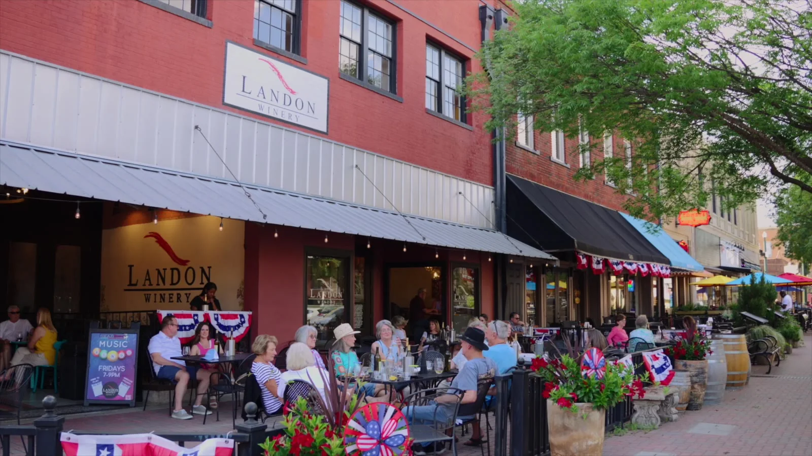 Diners on a restaurant patio along a main street.